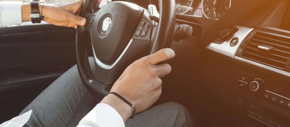 Affordable car gadgets displayed by a man in a white sweater.